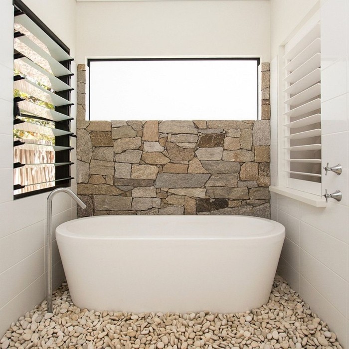 salle-de-bain-ultra-chic-baignoire-blanche-murs-en-pierres-beiges-baignoire-balnche