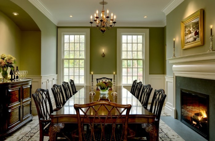 peinture-salle-à-manger-verte-pièce-spacieuse-lustre-somptueux-table-en-bois-massive-chaises-en-bois-design-intéressant-magnifique-cheminée-qui-apporte-la-sensation-de-chaleur