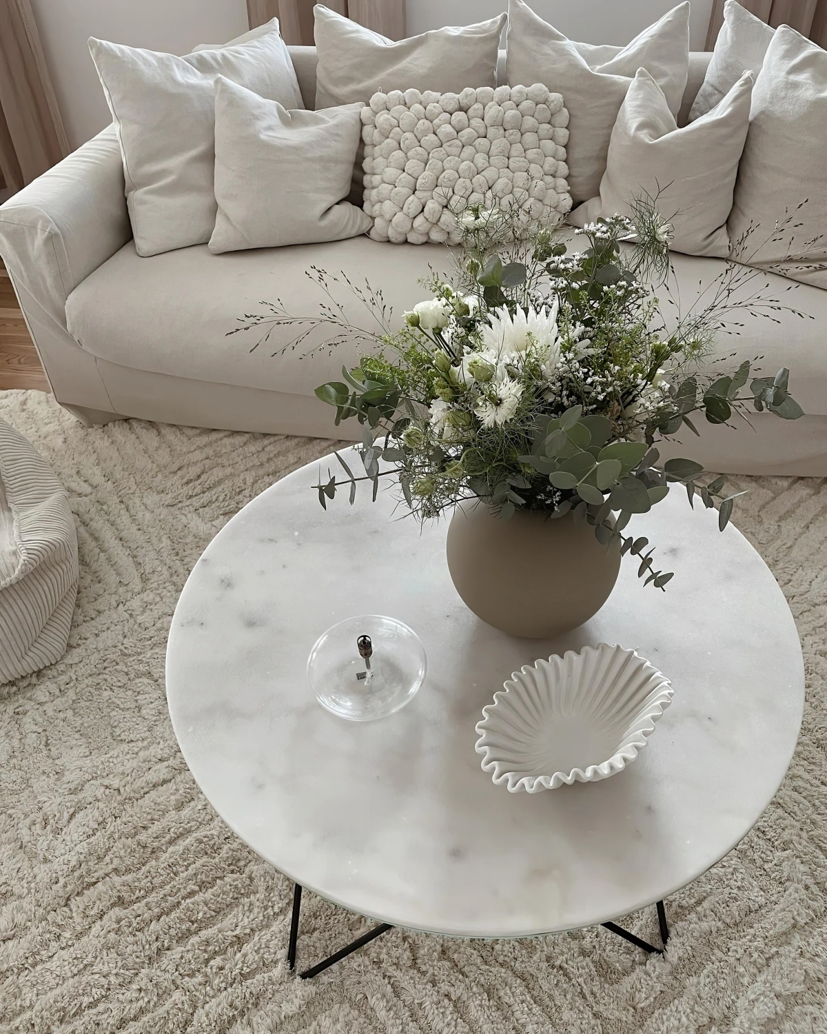 table basse marbre ronde bouquet eucalyptus canape beige coussins