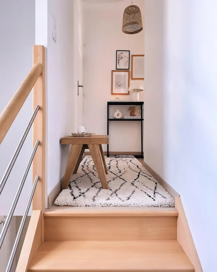 escalier en bois clair tapis doux en noir et blanc tabouret