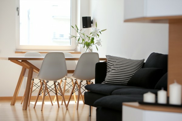 jolie-salle-de-séjour-pour-la-maison-unique-avec-des-chaises-scandinave-et-canapé-noir