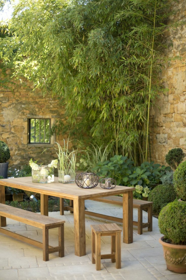 1-beau-jardin-avec-grande-table-de-jardin-en-bois-plantes-vertes