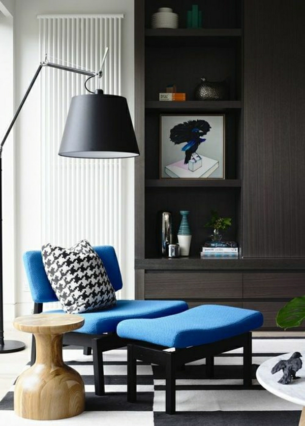 canapé-bleu-avec-lampe-liseuse-noir-tapis-blanc-noir-bibliothèque-commode-en-bois