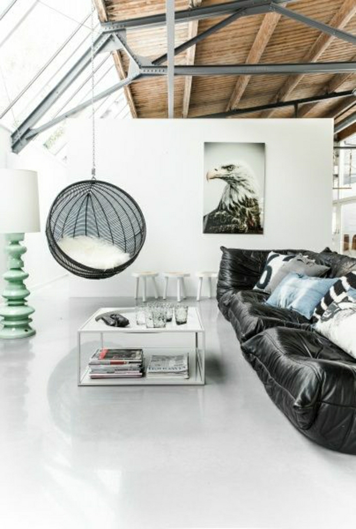 canapé-en-cuir-noir-salon-mansardé-plafond-en-bois-murs-blancs-peintures