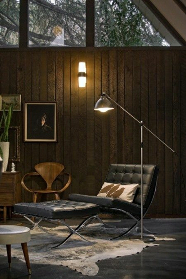 lampe-de-lecture-en-fer-canapé-en-cuir-noir-murs-en-bois-peintures-sol-en-lin