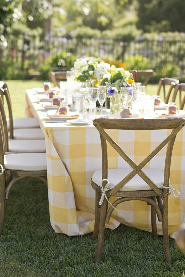 nappe-jaune-blanche-aux-carreaux-décoration-de-table-de-fleurs-chaises-rustiques-en-bois