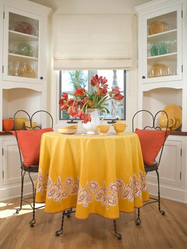 nappe-jaune-de-table-chaises-en-fer-forgé-fleurs-de-table-fenetre