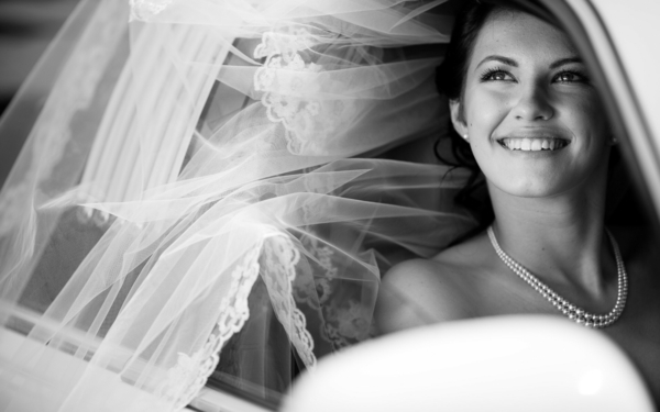 photographie-noir-et-blanc-portrait-mariée-robe-sourire-perles-jolie