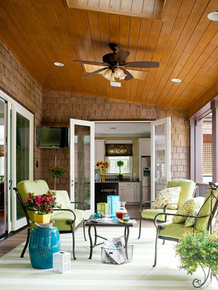porch-avec-ventilateur-lustre-insolite-toit-en-bois-chaises-en-fer-forgé-verts-maison-extérieur