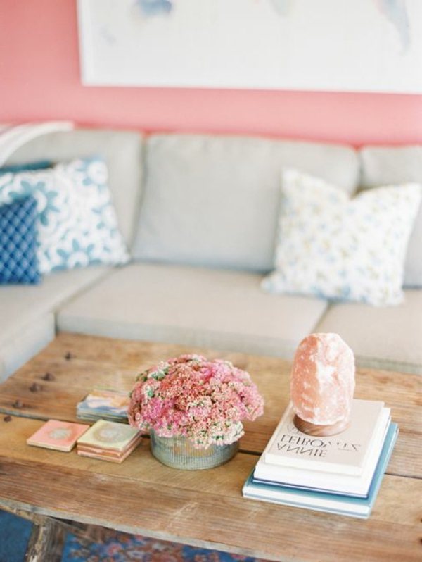 table-basse-avec-palette-canapé-gris-murs-roses-fleurs-livres