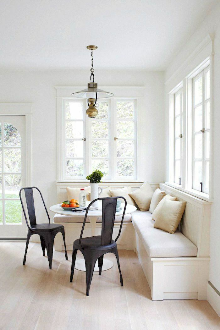 canapé-beige-table-tulipe-plastique-blanche-lustre-salle-de-séjour-moderne-chaise-noire