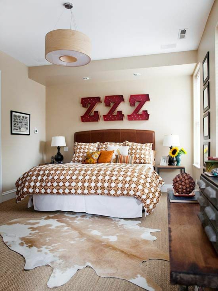 chambre-a-coucher-avec-un-tapis-en-peau-de-vache-blanc-marron-linge-de-lit-coloré-déco-mural