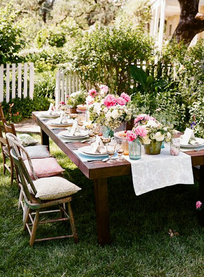 chemin-de-table-blanc-fleurs-sur-la-table-chaises-en-bois-de-jardin-set-de-table