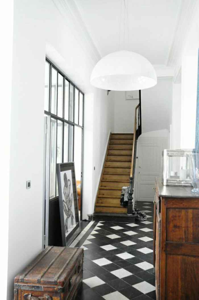 escalier-en-bois-carrelage-blanc-noir-mur-blanc-lustre-blanc-meubles-en-bois-foncé