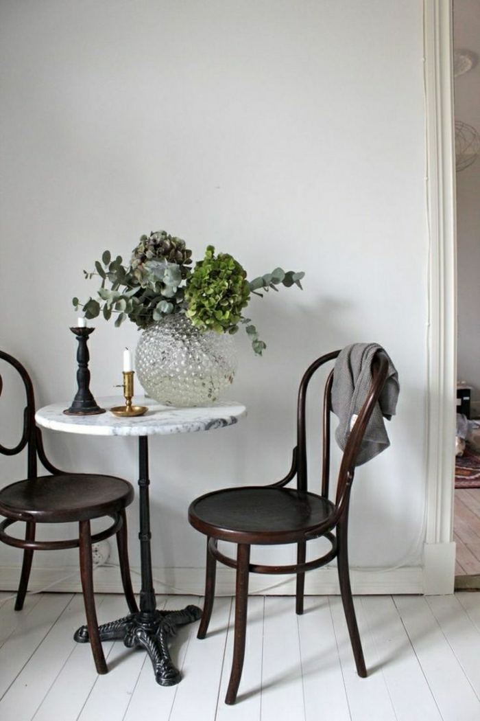 petite-table-en-marbre-fleurs-sur-la-table-chaise-en-bois-sol-en-plancher-blanc