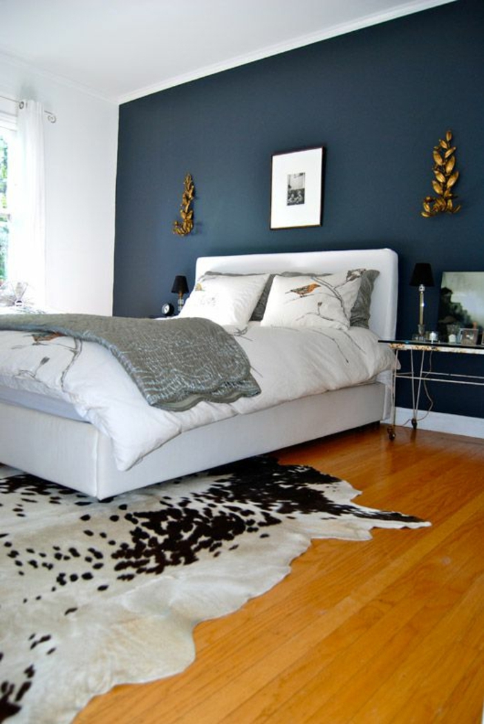 salle-de-coucher-sol-en-parquet-mur-bleu-foncé-lit-blanc-chambre-lumière