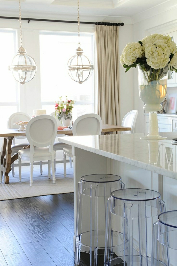 sol-en-parquet-table-en-bois-fleurs-sur-la-table-chaise-en-bois-blanc-lustre-chaise-transparente