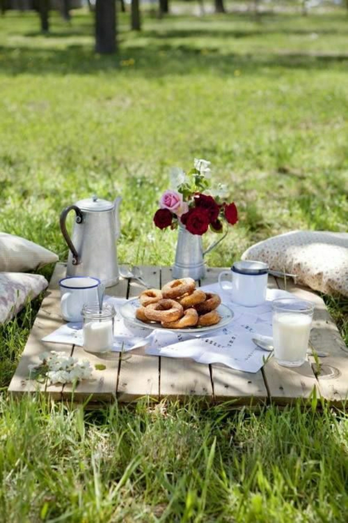 table-de-picnic-pelouse-vert-fleurs-sur-la-table-en-bois-jardin-ensoleilé