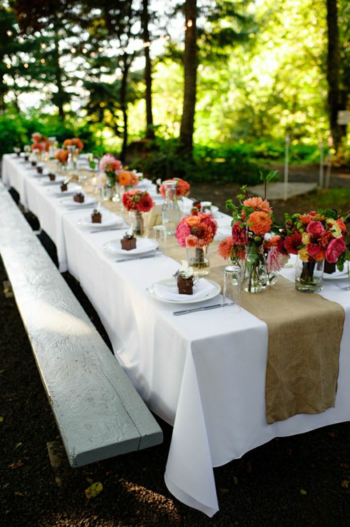 table-pique-nique-bois-nappe-blanche-fleurs-sur-la-table-dessert-chemin-de-table