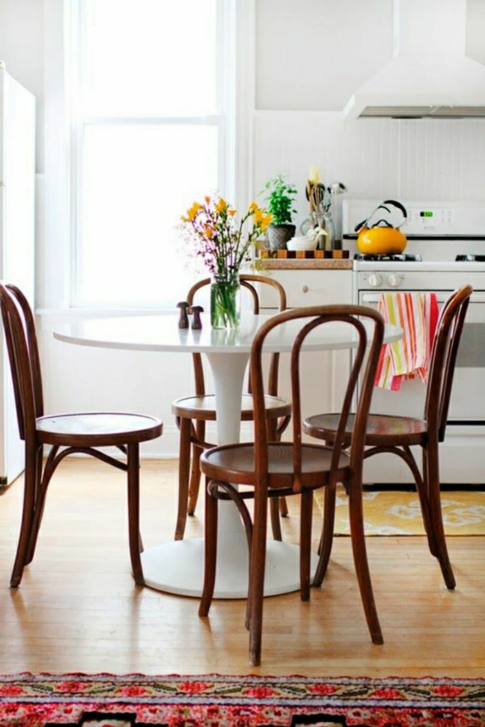 table-ronde-blanche-table-tulipe-tapis-coloré-sol-en-parquet-fleurs-sur-la-table