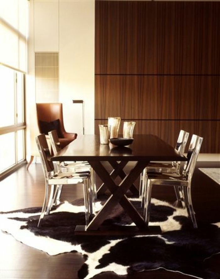 tapis-en-peau-de-vache-parquet-foncé-table-en-bois-chaises-transparentes-déco-brun