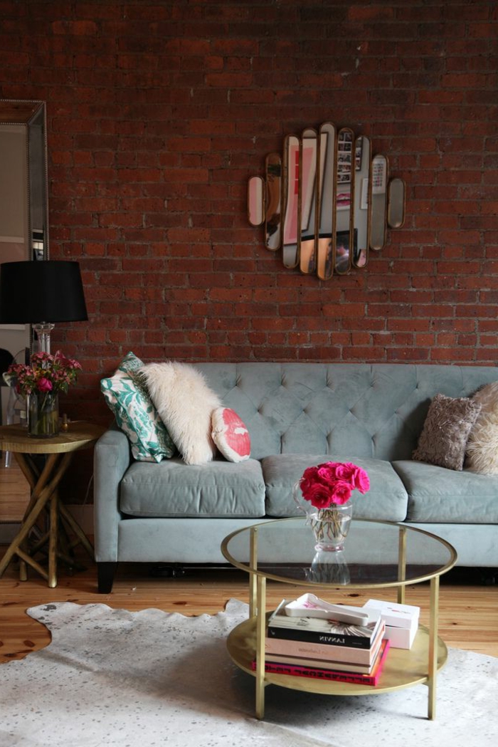 table-basse-ronde-sofa-gris-mur-briques-et-miroir-décoratif
