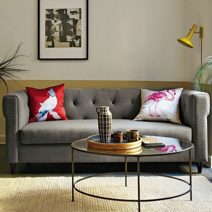 table-basse-ronde-verre-et-acier-près-d'un-sofa-gris