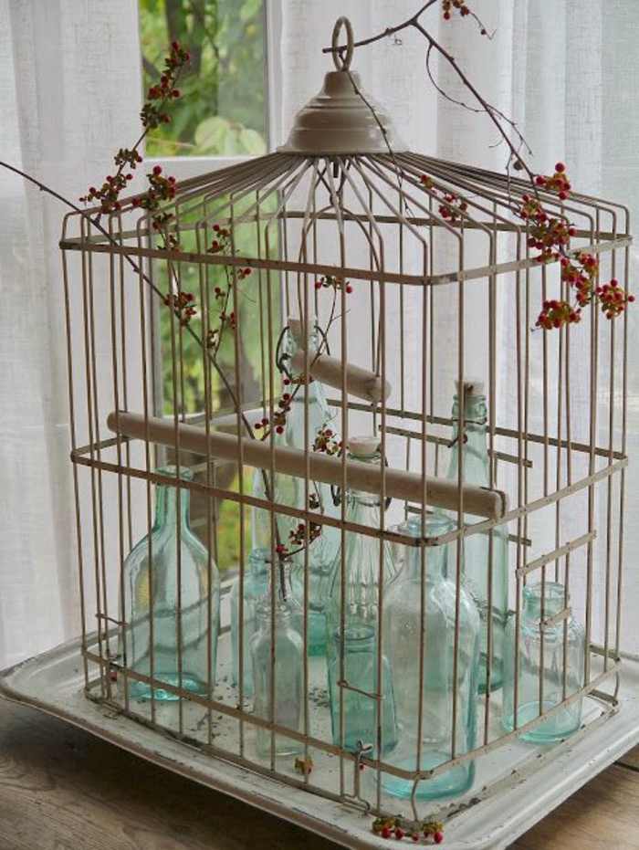 cage-à-oiseaux-décorative-remplie-de-bouteilles-turquoises
