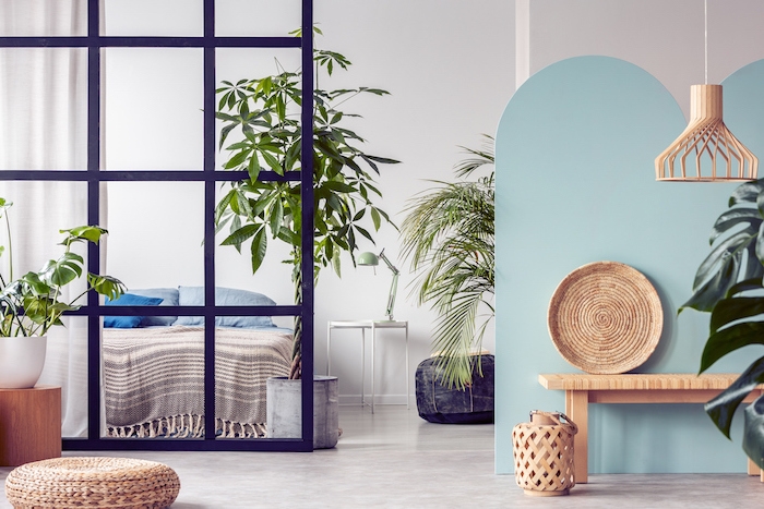 urban jungle in bright white and blue bedroom interior with partition
