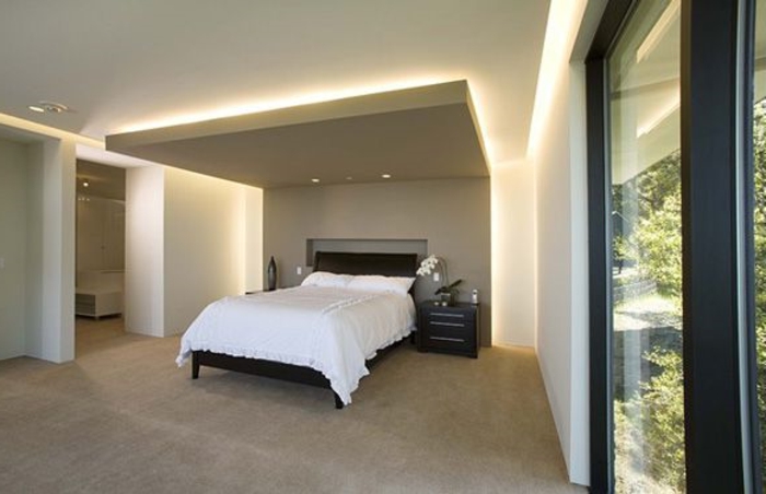 plafond-faux-dans-la-chambre-à-coucher-couverture-blanche-lampe-de-plafond-moquette-beige