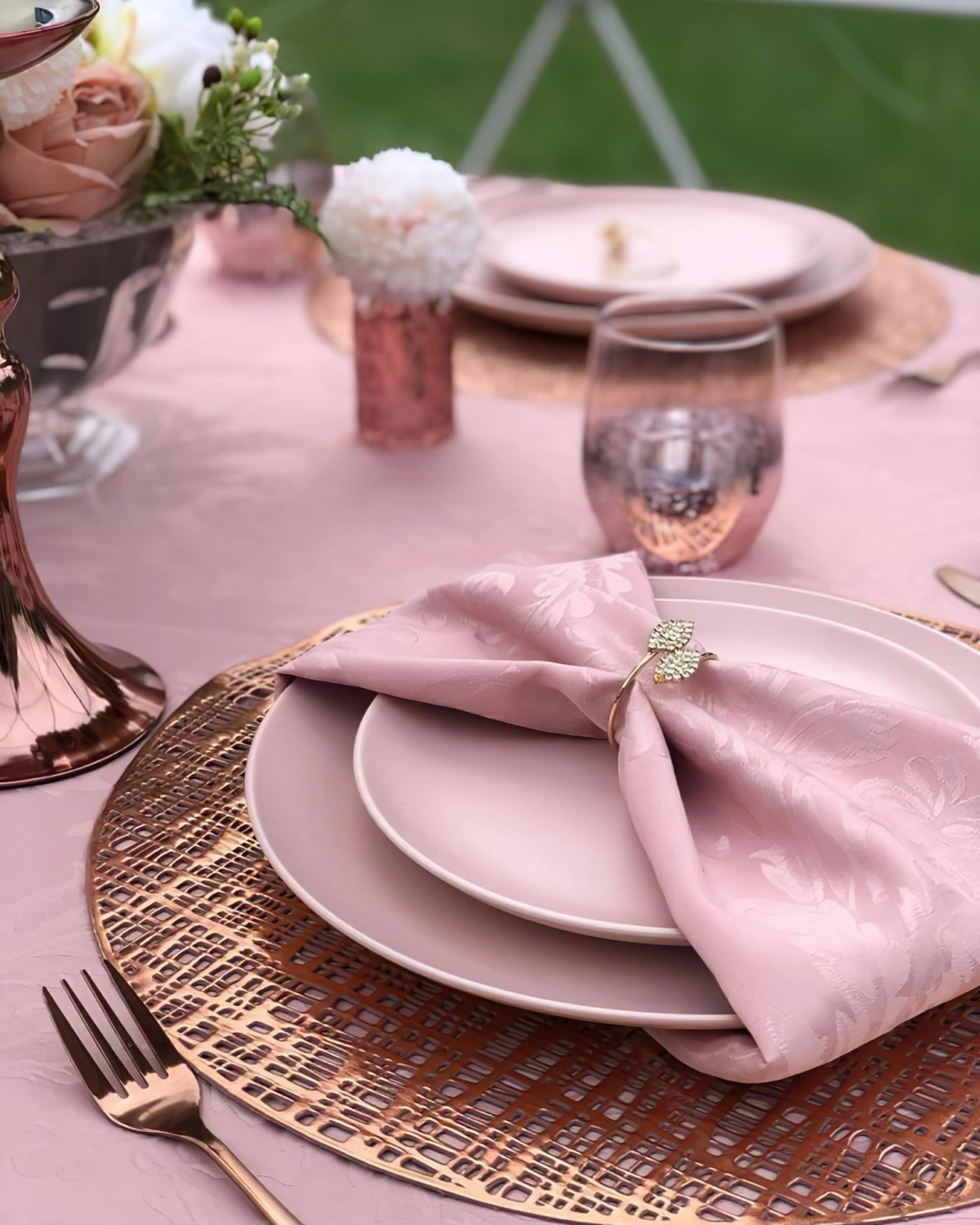 pliage de serviette rose anneau dore assiettes rose pastel nappe