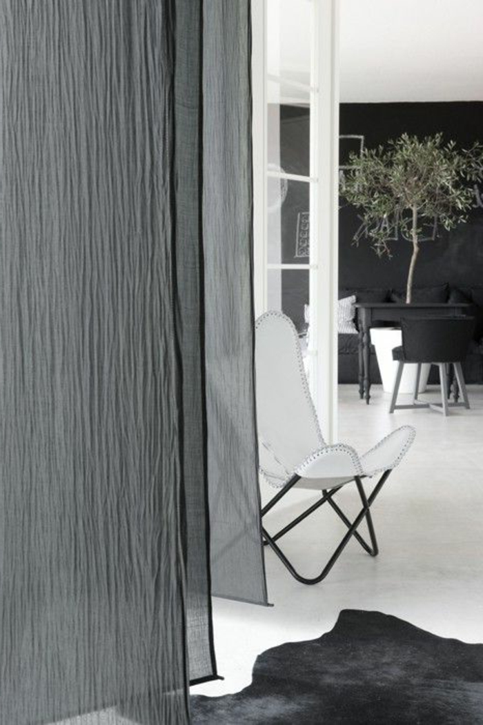 1-les-rideaux-voilages-dans-la-salle-de-séjour-avec-un-tapis-en-peau-d-animal-noir-et-rideaux-gris