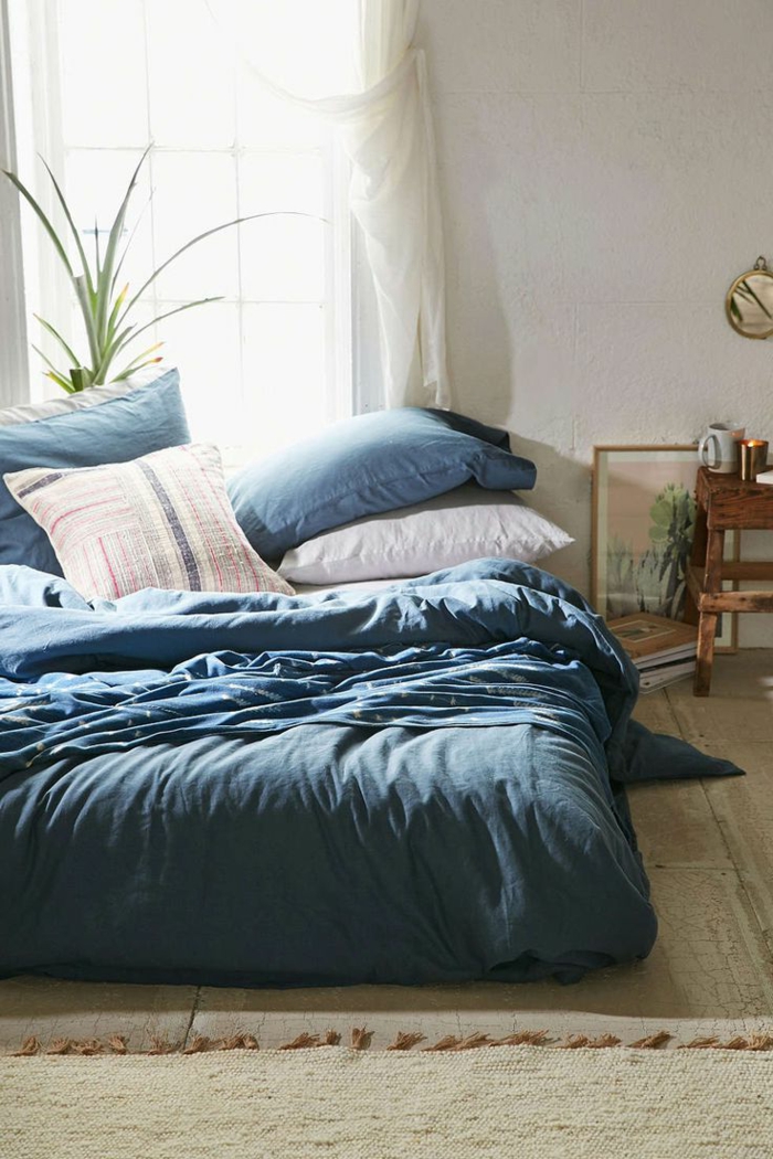 jolie-housse-de-couette-bleue-pour-la-chambre-à-coucher-tapis-beige-coussins-bleus