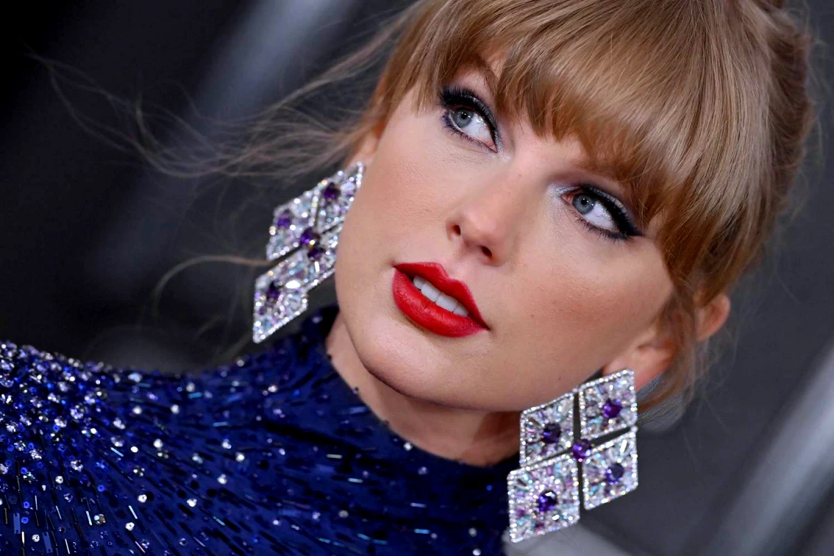 taylor swift couleur de cheveux tres clair chatain robe bleue boucles d oreilles strass