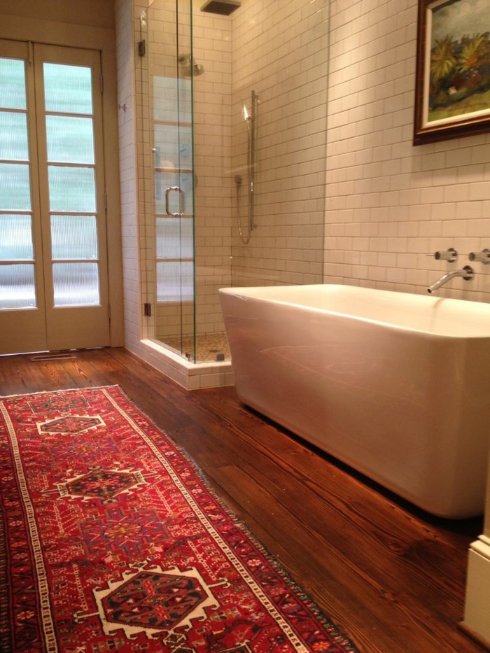 une-jolie-salle-de-bain-avec-carrelage-blanc-et-sol-en-parquette-en-bois-foncé