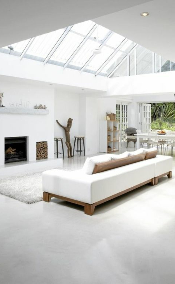 une-jolie-salle-de-séjour-avec-plafond-en-verre-et-sol-en-béton-ciré-gris-meubles-blancs
