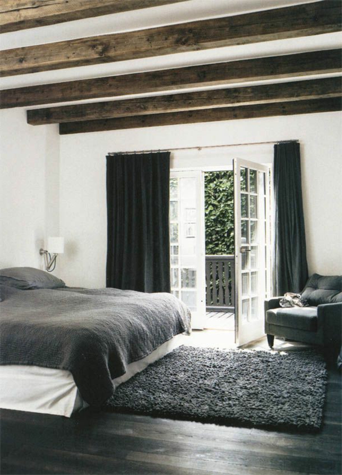 1-jolie-chambre-à-coucher-avec-tapis-gris-et-rideaux-noirs-longs-sol-en-parquet-noir-poutre-decorative-poutre-chene