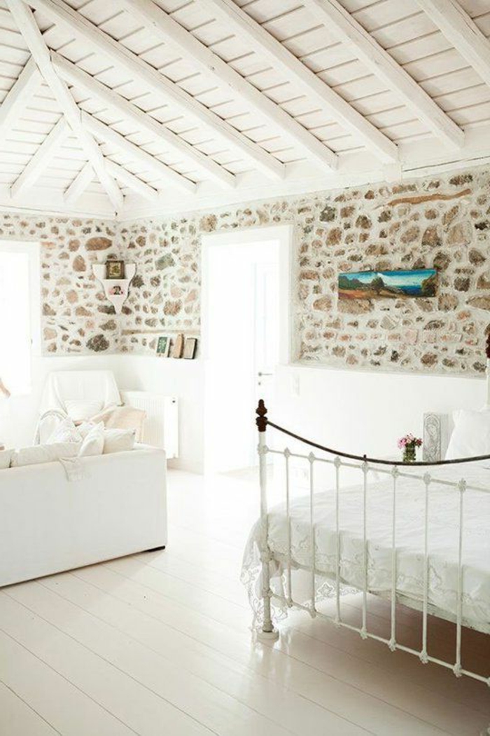 1-salon-avec-mur-en-pierre-de-parement-intérieur-et-sol-en-planchers-clairs-lit-en-fer