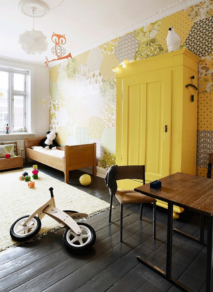 1-une-jolie-chambre-d-enfant-avec-meubles-jaunes-mur-en-papier-peint-coloré-sol-en-planchers-noirs