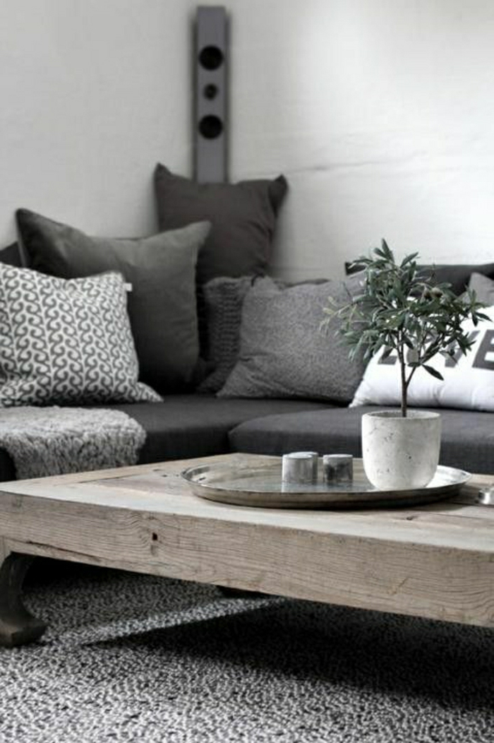 2-1-coussin-gifi-coussin-60x60-gris-blanc-table-en-bois-massif-murs-blancs-tapis-gris