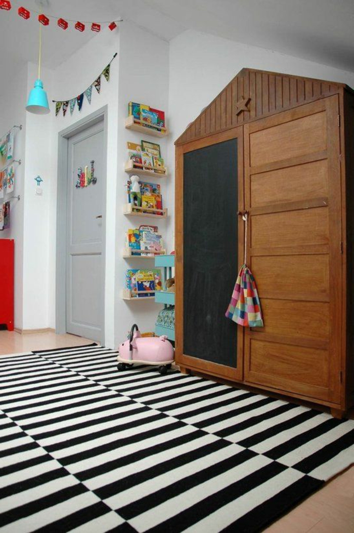 joli-armoir-en-forme-de-triangle-avec-tapis-à-rayures-blancs-noires-murs-blancs