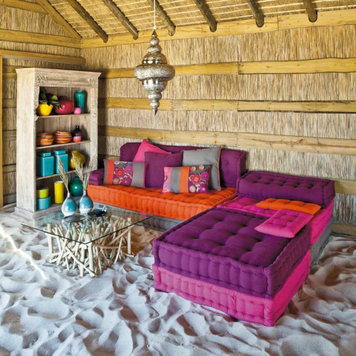 joli-salon-d-exterieur-marocain-avec-meubles-violets-canape-violet-sur-le-sable-et-table-en-verre-et-bois