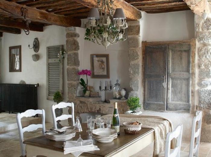 jolie-cuisine-avec-mur-en-pierre-de-parement-intérieur-table-en-bois-et-chaises-blanches