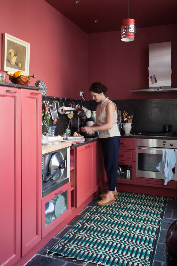 jolie-cuisine-avec-murs-bordeaux-meubles-de-cuisine-rouges-tapis-coloré-dans-la-cuisine