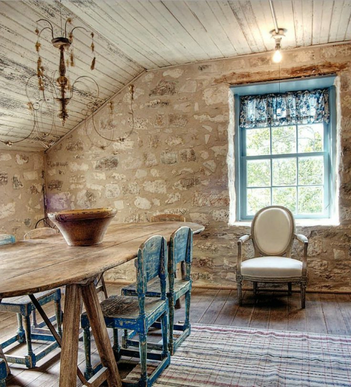 jolie-salle-de-sejour-avec-mur-en-pierre-de-parement-intérieur-et-tapis-coloré-sur-le-son-en-planchers