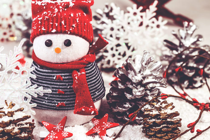 bonhomme de neige en chaussette blanche avec pull et écharpe recyclés et bonnet rouge tricot, activité manuelle noel et deco