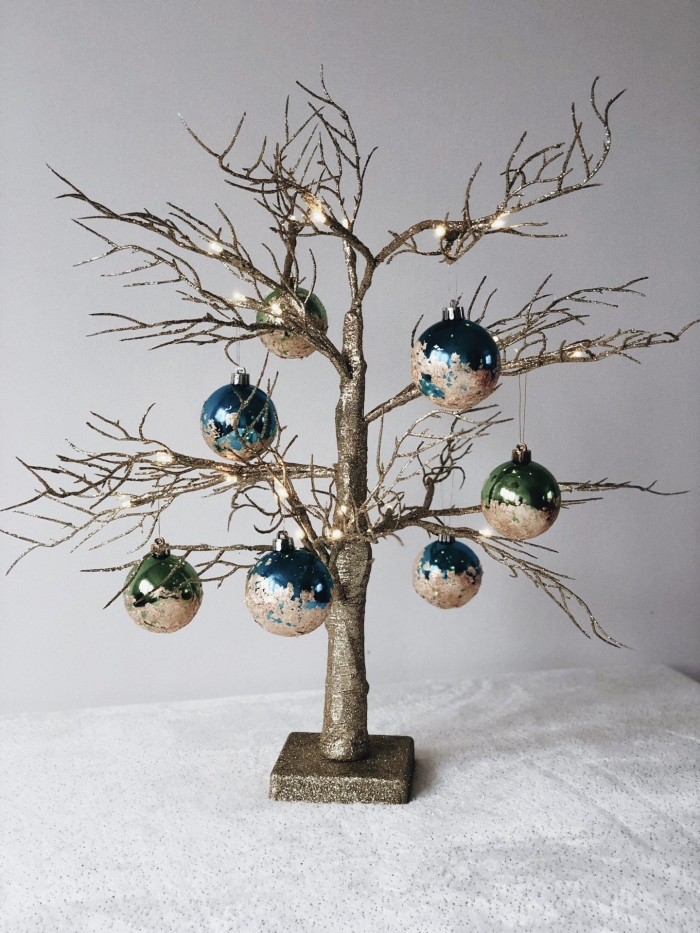 decoration sapin de noel stylée, modèle d'arbre de Noël repeint en glitter doré et décoré avec ornements personnalisés à effet métallique