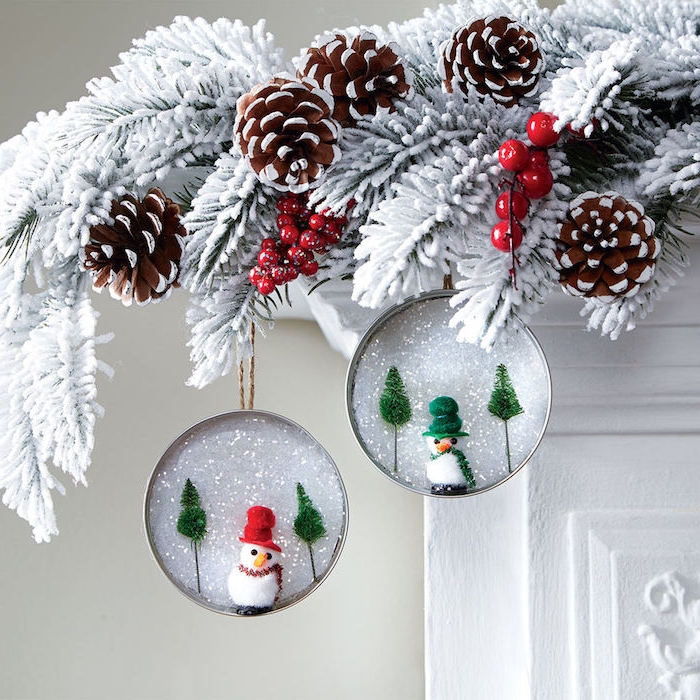 deco cheminee de noel en couvercles de pot en verre avec neige artificielle et figurines bonhomme de neige accrochés sur branches de pin blanchies, diy noel deco facile a faire