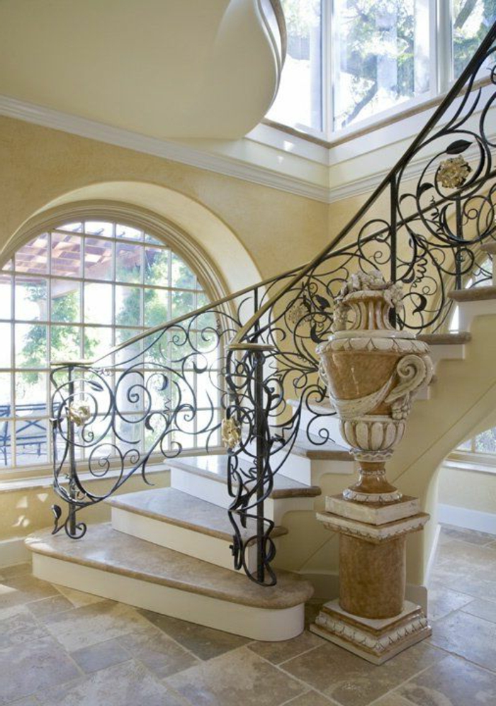 escalier-tournant-dans-l-entree-moderne-avec-sol-en-carrelage-beige-et-rambarde-en-fer-forgé
