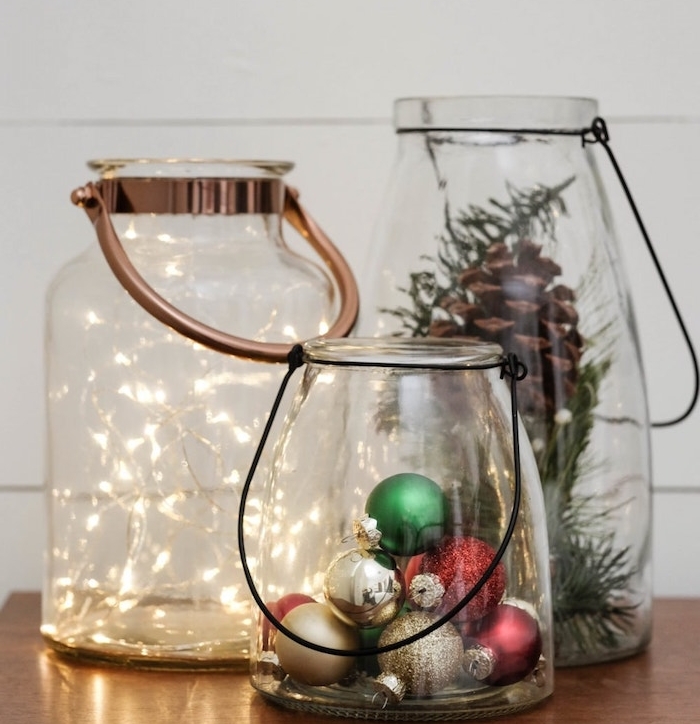 lanternes decoratives en gros bocaux en verre avec manche et deco de guirlande lumineuse, boules de noel, pommes ou branches de pin